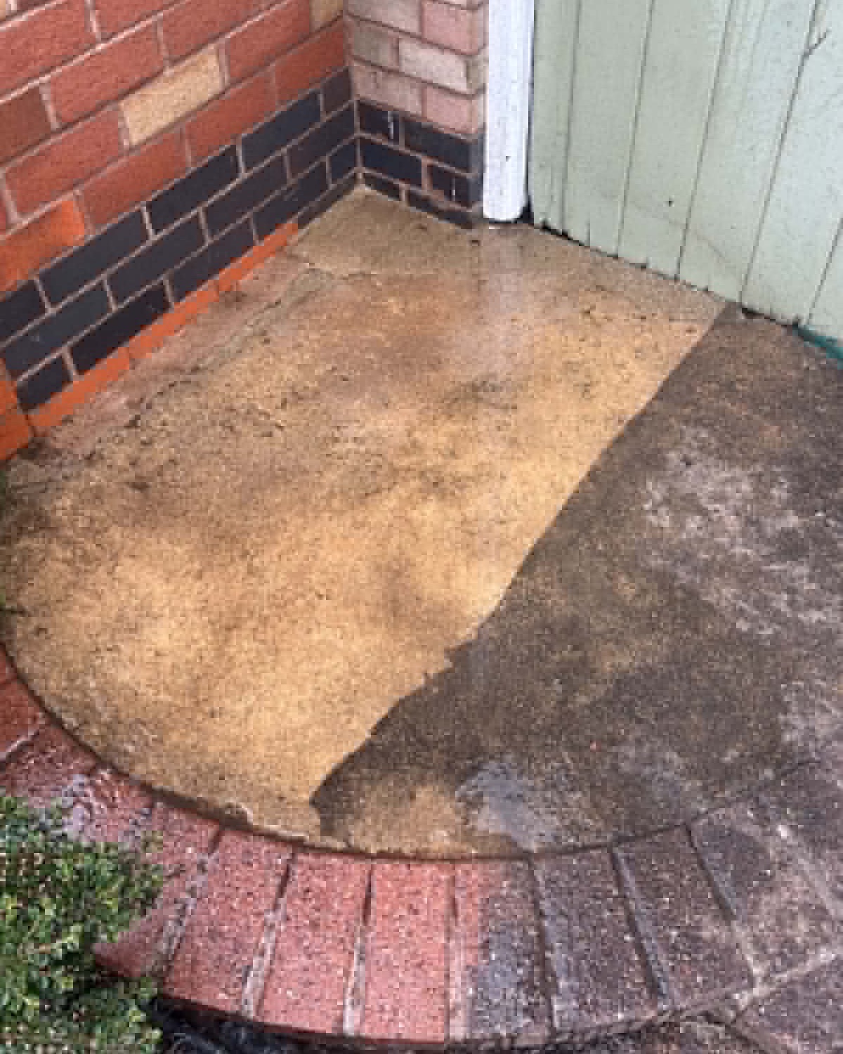 Patterned concrete patio half pressure-washed by Pressure Point — clean buff stone beside the dirty grey surface